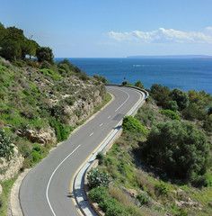 Coastal road on Ibiza with blue sky and sea in the background