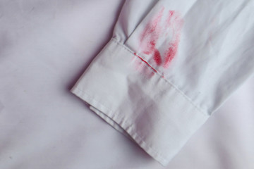 Dirty lipstick stain on white shirt. Stain remover concept