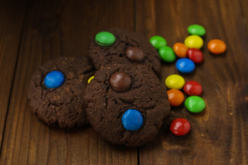 Tasty brownie cookies with colorful candies on table, close up