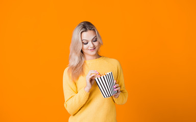 Young woman watching a movie and eating popcorn.