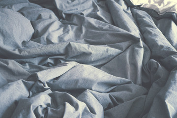 Crumpled gray fabric. Bed in the morning. The spread out bed. Linens.