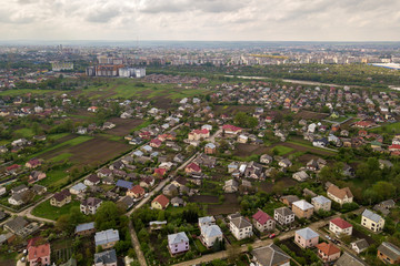 Aerial landscape of small town or village with rows of residential homes and green trees.