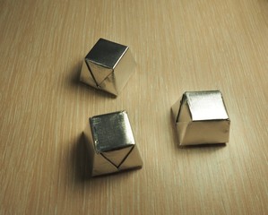 Photo of  sweets in a silver wrapper on a light wood background