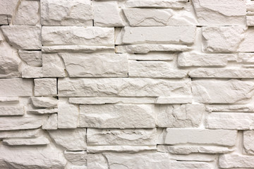 Close-up of white solid limestone wall or stone fence. Abstract copy space background, Bricklaying, construction and masonry concept.