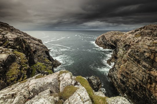 Gloomy scenery of two mountains standing in the ocean in Isle of Lewis, Outer Hebrides, Scotland, UK