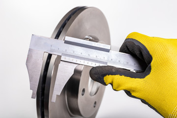Measuring brake discs with a caliper. Car parts workshop measurements.