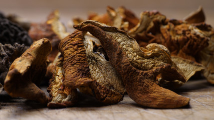 A closeup collection of dried mushrooms on a cutting board
