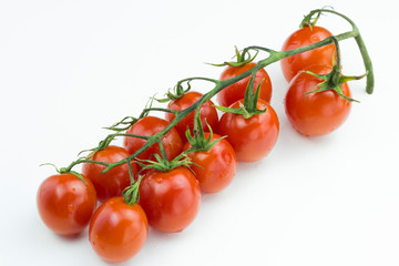 Bunch of red cherry tomatoes with water drops isolated on a white background. Close up view