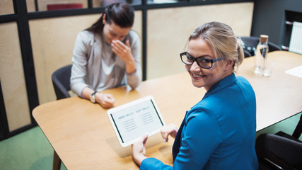 Job interview. The recruiter holds a tablet with a check list of the necessary skills of the...