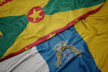waving colorful flag of canary islands and national flag of grenada.