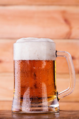 Mug of beer on rustic wooden background with copy space