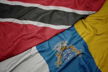 Fototapeta premium waving colorful flag of canary islands and national flag of trinidad and tobago.