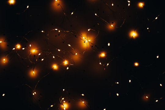 Warm White LED String Lights On Star Pattern Black Background. Modern Festive Interior Decor.