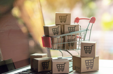 Shopping online concept - Parcel or Paper cartons with a shopping cart logo in a trolley on a...