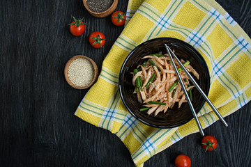 Salad with daikon radish, green onions, honey and red chili powder. Asian salad. Flat lay. Space for text. Dark background.