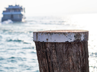 Wood mooring pole with a ferry in background