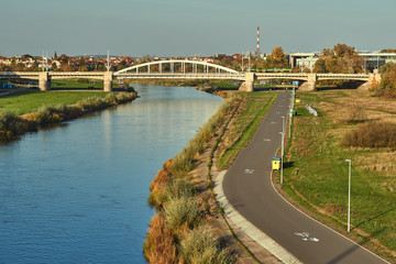 Bicycle path over the Warta river and steel bridge in the city of Poznan.