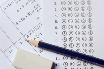 Pencil and eraser on answer sheets or Standardized test form with answers bubbled. multiple choice...