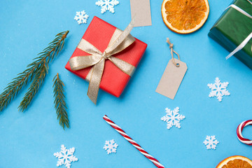 winter holidays, new year and christmas concept - gift boxes, fir tree branches, tags and decorations on blue background