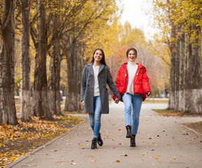 Two girlfriends in a gray wool coat and a red down jacket