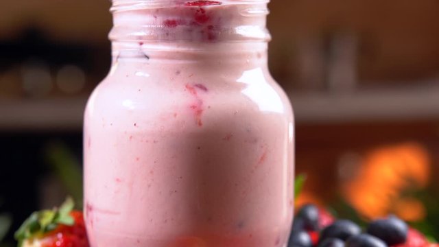 Fresh forest berries, healthy fruit, nourishing blended smoothie with strawberries and blueberries, 2in1 video shot in 4K. Camera moving from bottom to top, vitamin complex, full body detox. Mixing