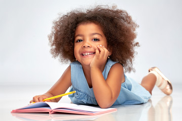 childhood, creativity, drawing and people concept - happy little african american girl with...