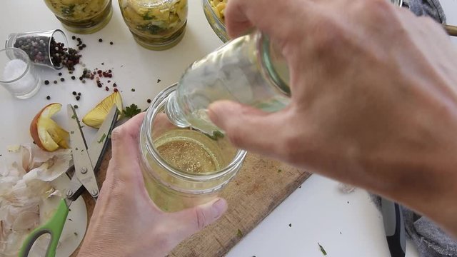 Personal perspective of woman hands preparing Amanita caesarea (known as Caesar's mushroom). Put the mushrooms in jars in oil