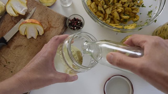 Personal perspective of woman hands preparing Amanita caesarea (known as Caesar's mushroom). Put the mushrooms in jars in oil