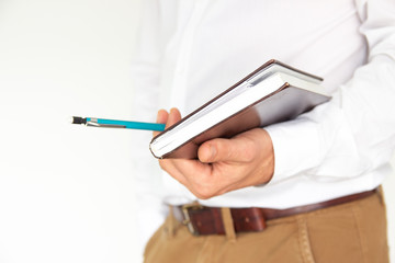 A man holds in his hands a notebook, notebook, diary and pen. Business concept isolated on white background.