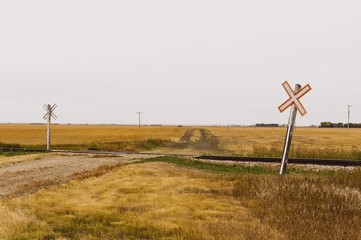 Railroad crossing a gravel road with iconic crossing signs