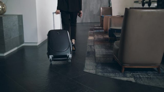 Business woman with travel suitcase arriving in hotel at vacation