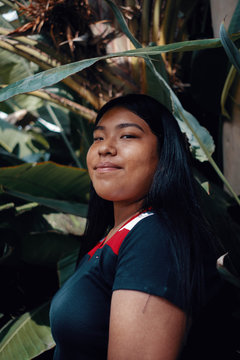 Portrait of teen girl surrounded with tropical plants