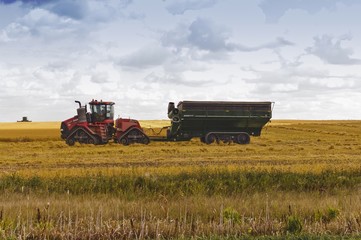 Fototapeta premium Farm tractor and grain cart