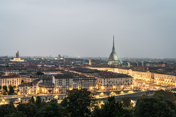 Fototapeta na wymiar The city of Turin at sunset, great view of the Mole Antonelliana when the city lightning up