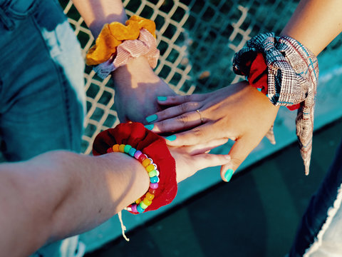 Three hands with bracelets overlapping