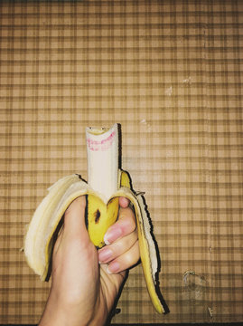 Woman's hand holding bitten banana