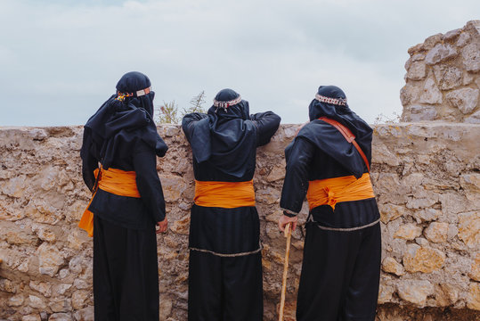 People with traditional attire standing against wall