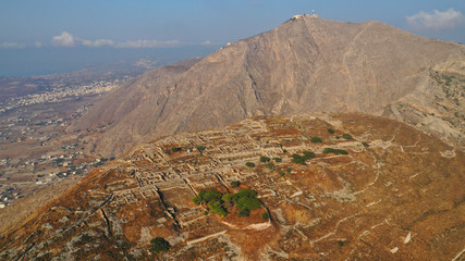 Aerial drone photo of iconic archaeological site of ancient Thera or Thira built uphill with...