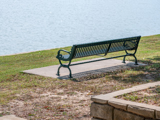 a green bench near the edge of the water