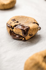 Paleo Chocolate Chip Cookies Made with Coconut and Almond Flour on Baking Sheet / Paper. Organic Food with Melted Chocolate.