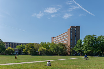 Outdoor sunny view of Innerer Grüngürtel, state park, in front of buildings of University of cologne against blue sky. in Cologne, Germany. - obrazy, fototapety, plakaty