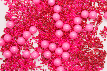 This is a photograph of Pink round sprinkles isolated on a White background