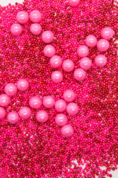 This is a photograph of Pink round sprinkles isolated on a White background © dana_zurki