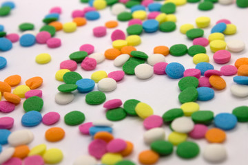 This is a photograph of colorful round sprinkles isolated on a White Background