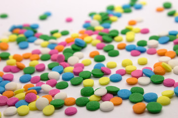 This is a photograph of colorful round sprinkles isolated on a White Background
