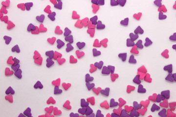 Fototapeta na wymiar This is a photograph of Pink and Purple heart sprinkles isolated on a White background