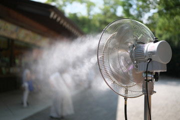 Fototapeta Aichi,Japan-September 11, 2019: A mist fan operating to cool people visiting a souvenior shop on a hot summer day obraz