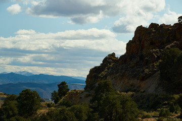 Naklejka premium Rocky Bluffs overlooking a Nevada canyon with mountains in the background
