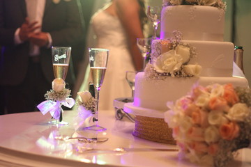 Wedding cake with candles and champagne, celebration, space for text, marketing concept, roses bouquet, couple, table.