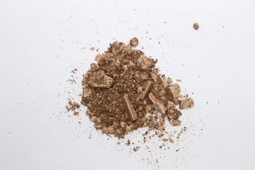 This is a photograph of a Bronze metallic powder Eyeshadow isolated on a White background